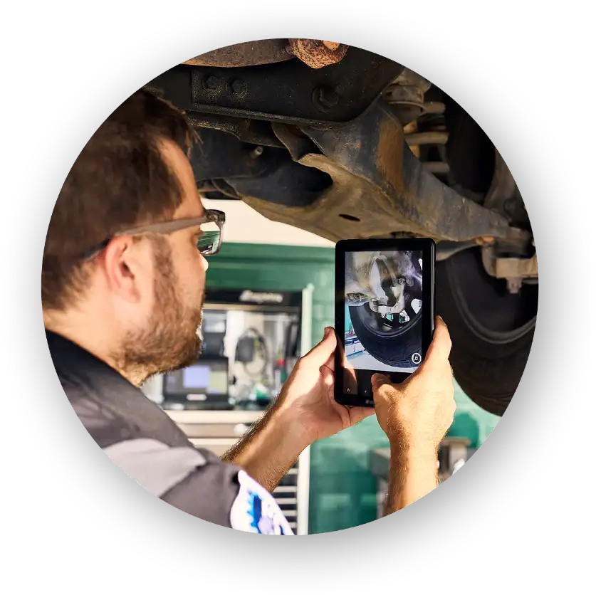 Christian brothers automotive mechanic taking picture of tire