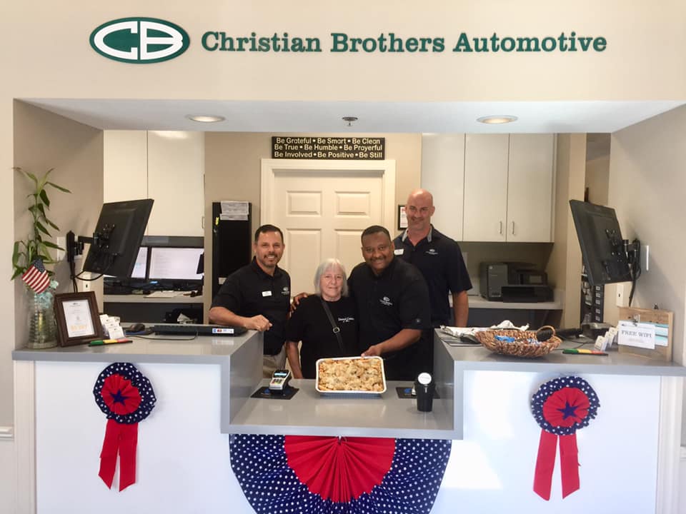 christian brothers automotive team with food in shop