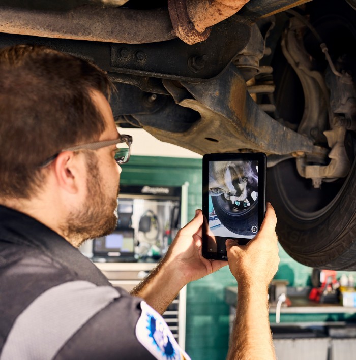 mechanic performing computer diagnostic on car