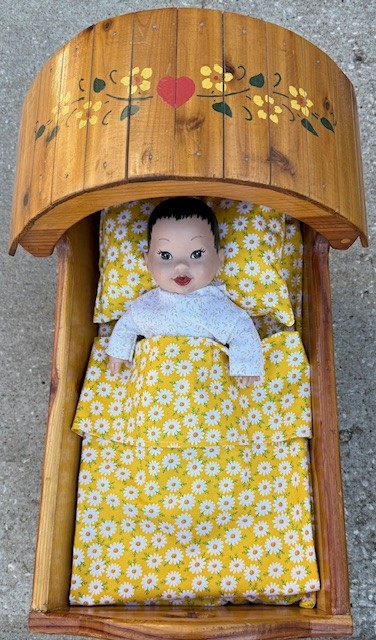 a babydoll in a wooden crib